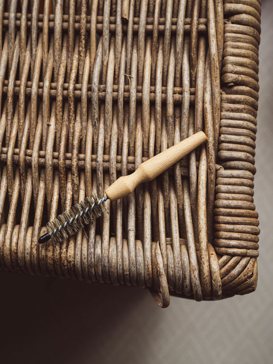 Bristle brush with wooden handle on a wicker surface